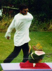 Rev. DeLuxe hacks a watermelon with a machete during a sacrifice in 1993